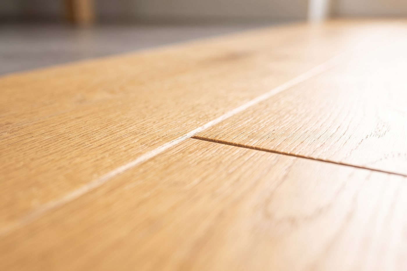 Close-up of the joint between two wide timber-look flooring planks, showing the tight seam and bevelled plank edges